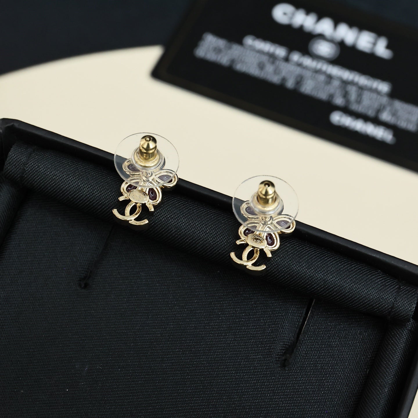 Chanel floral stud earrings with pink stones, gold-tone CC charm, clear post backs