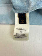 Light blue long-sleeve knit top with care label and Made in Italy tag