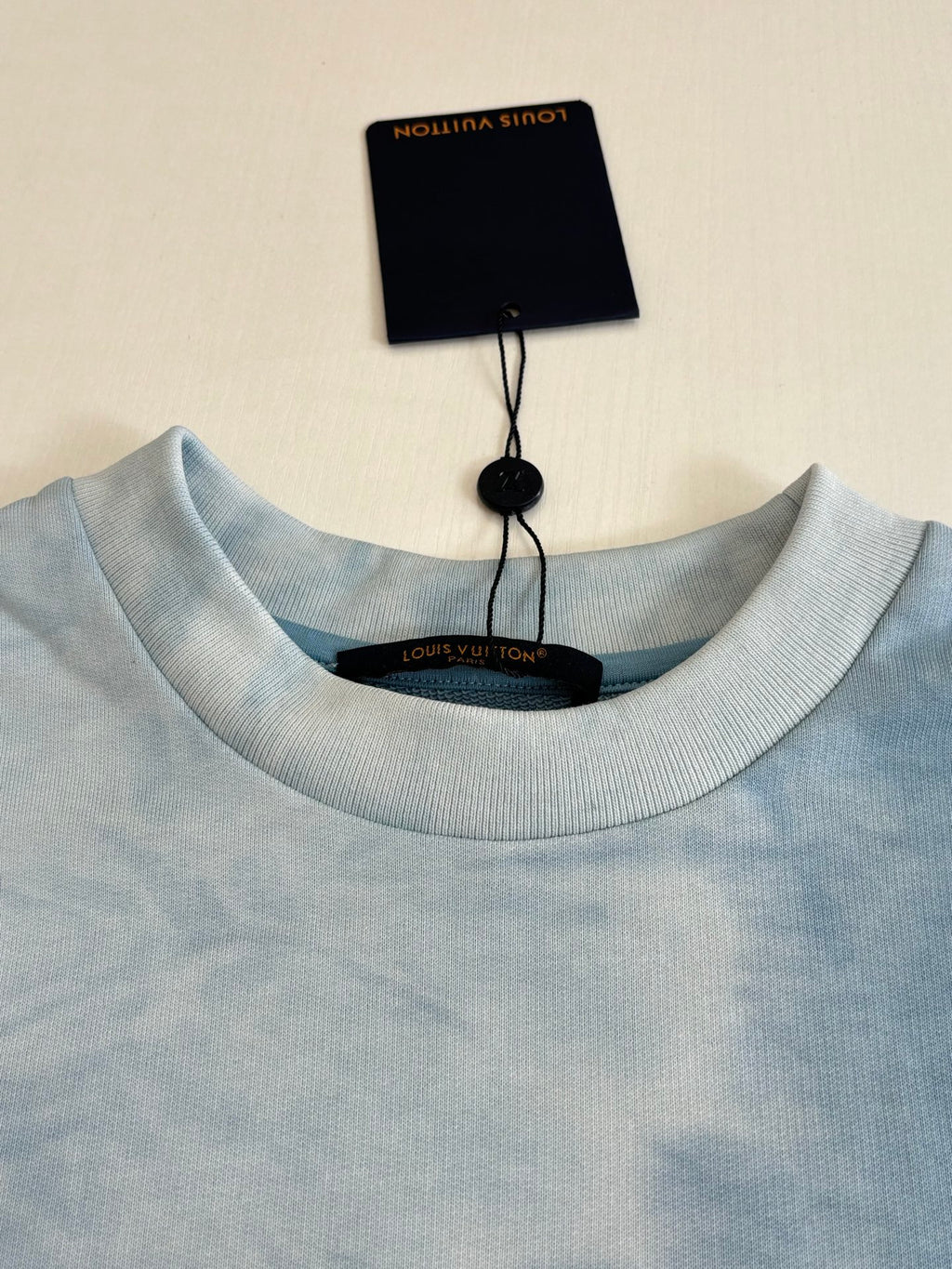Light blue ribbed crewneck sweatshirt collar with Louis Vuitton neck label