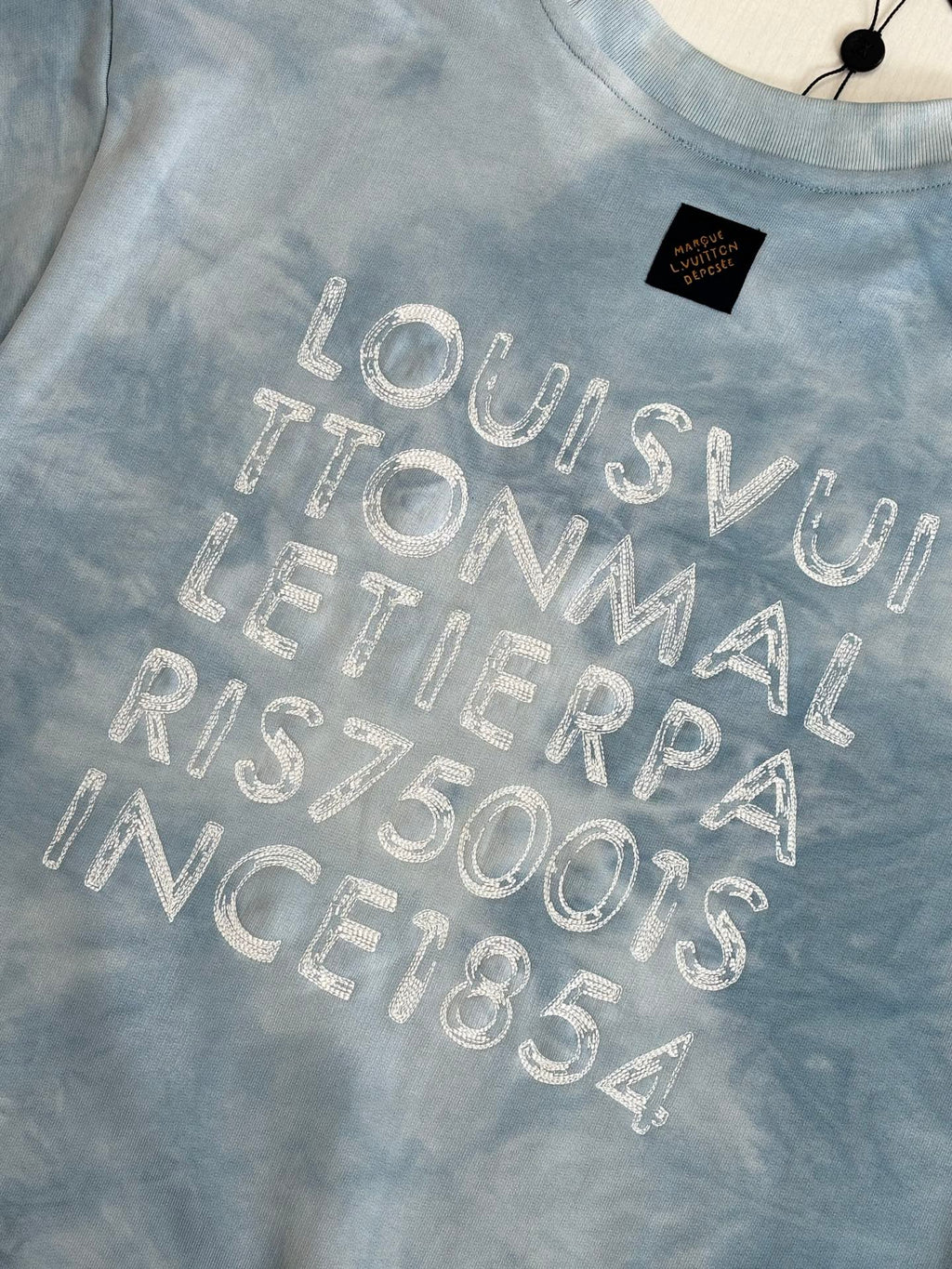 Light blue tie-dye sweatshirt with large glitter logo wordmark