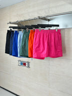 Set of colorful shorts on hangers: blue, green, orange and pink