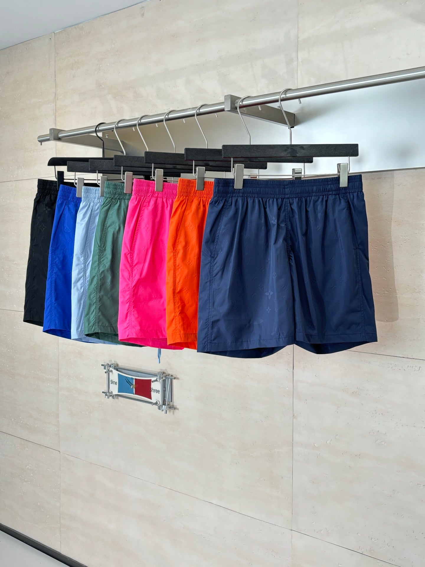 Set of shorts on hangers: navy, black, green, and bright pink