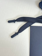 Navy drawstring ends and cords for shorts, with embossed branding