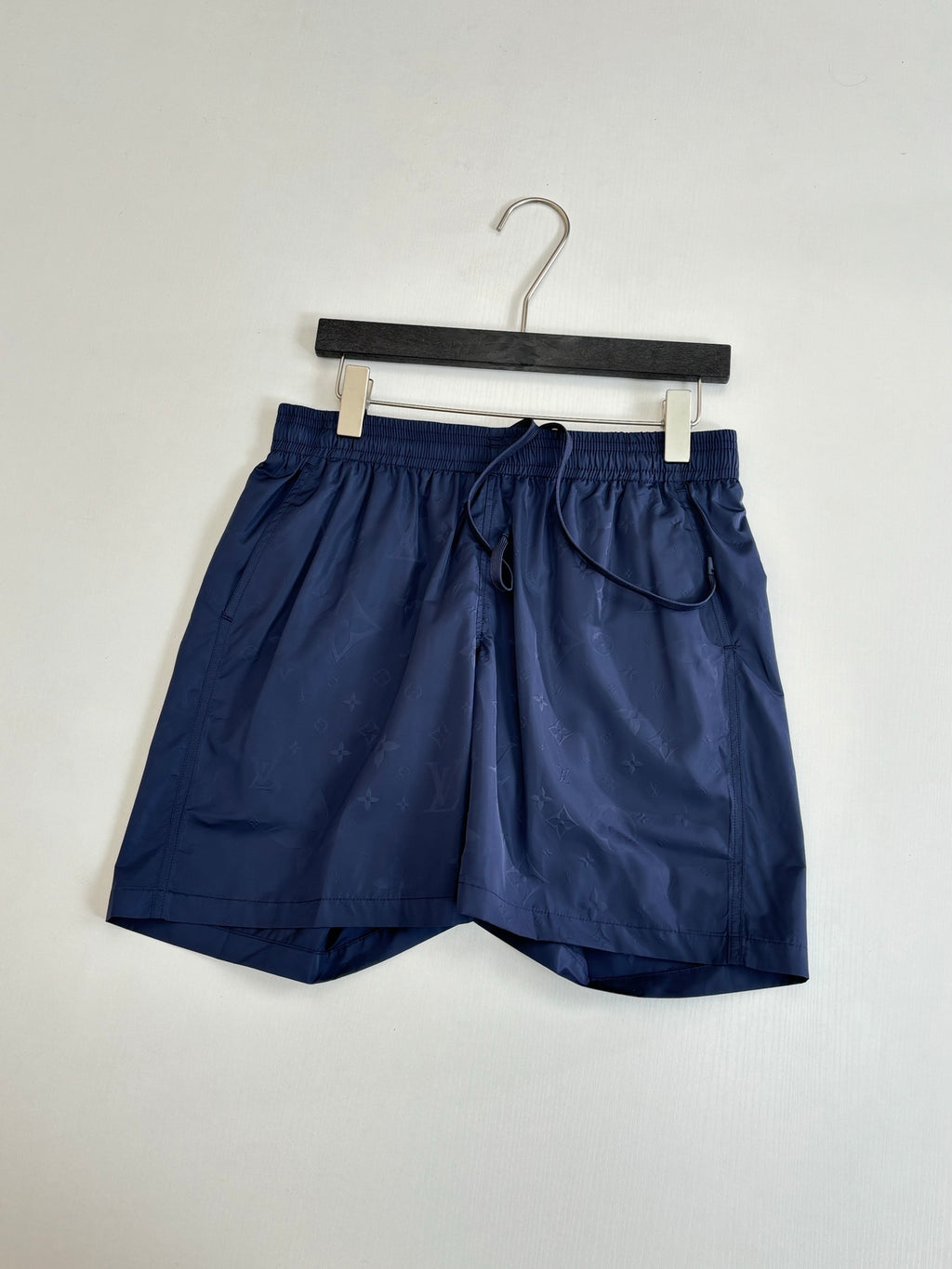 Navy shorts on hanger, elastic waistband and front drawstring cord