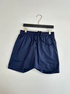 Navy shorts on hanger, elastic waistband and front drawstring cord