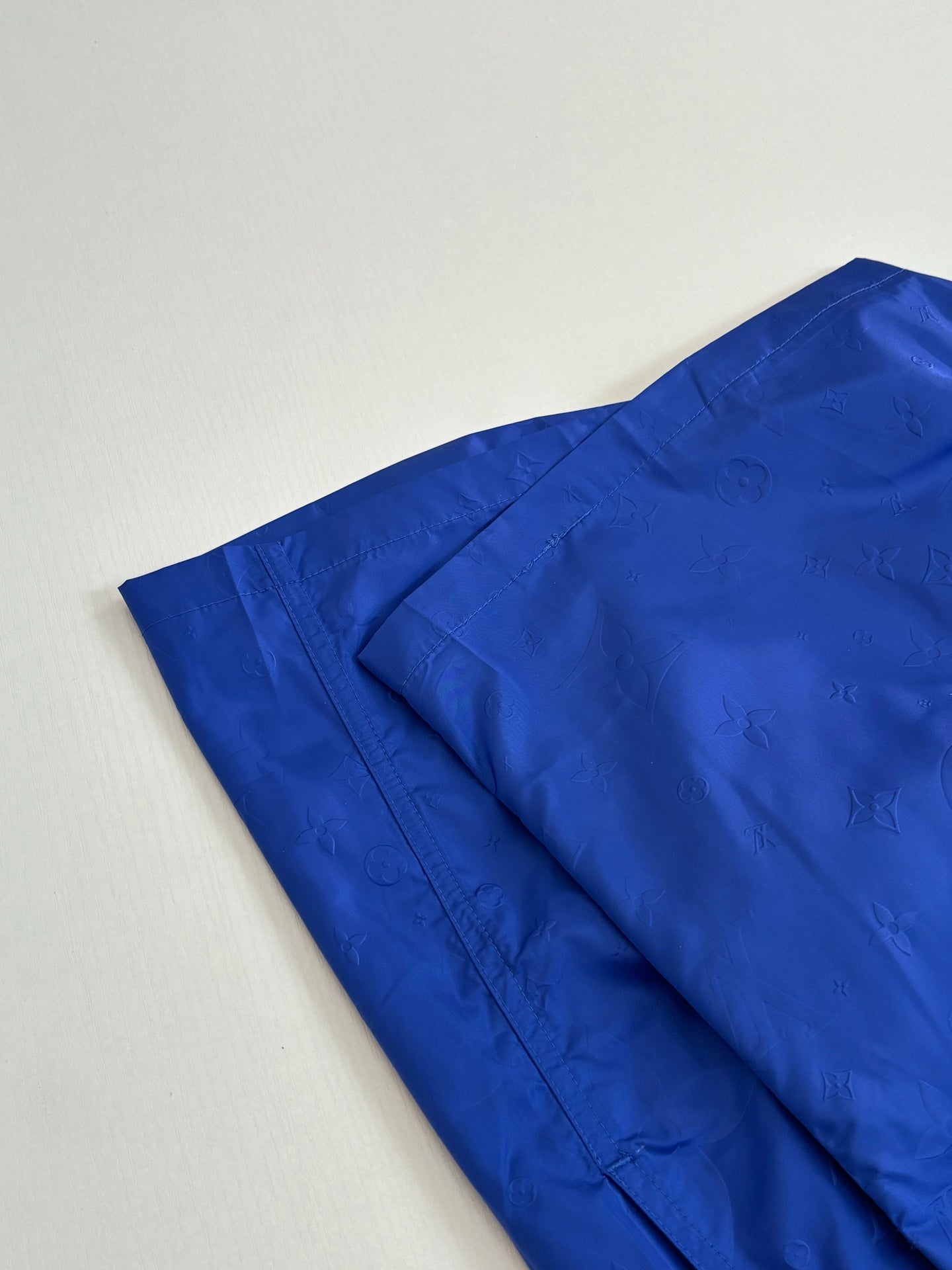 Folded blue shorts with subtle all-over embossed pattern
