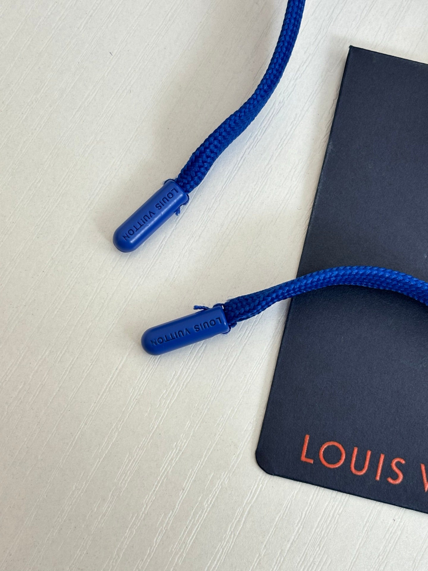 Blue drawstring and Louis Vuitton tag on blue shorts