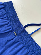 Blue shorts with elastic waistband, side pocket seam, and drawstring tie