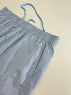 Close-up of light blue monogram shorts with drawstring and elastic waist