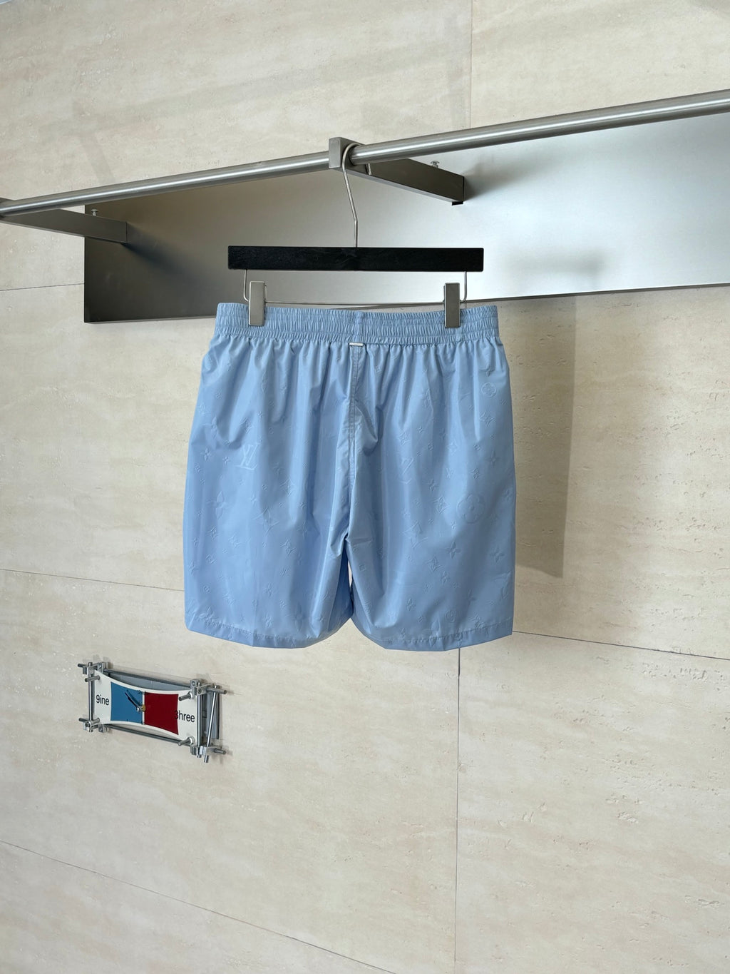 Light blue monogram shorts hanging view with elastic waistband