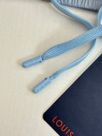 Light blue drawstrings with small printed text on monogram shorts
