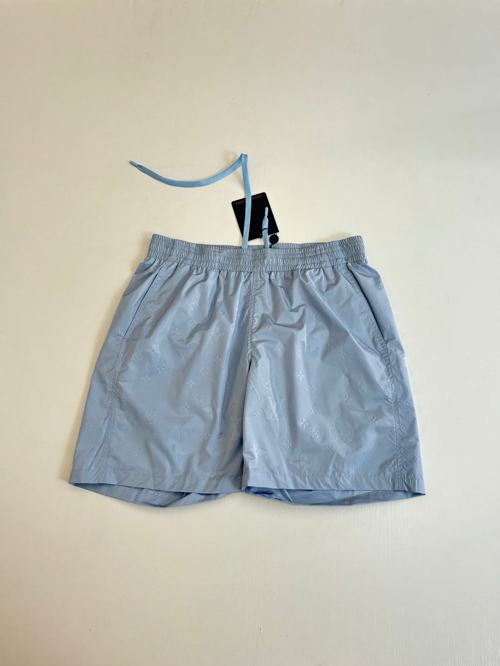 Light blue monogram shorts laid flat with elastic waistband