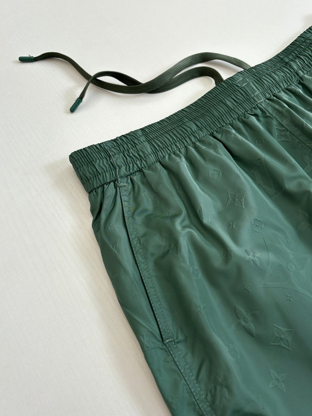 Green Louis Vuitton shorts close-up showing drawstring and gathered elastic waist.