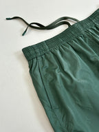 Green Louis Vuitton shorts close-up showing drawstring and gathered elastic waist.
