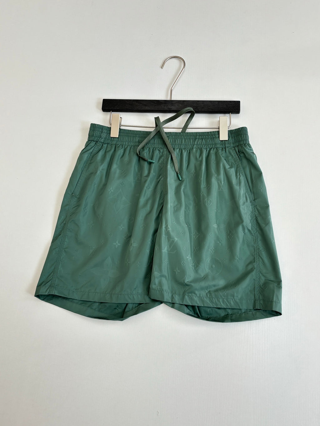 Green Louis Vuitton shorts, front view with elastic waistband and drawstring tie.