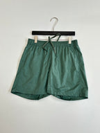 Green Louis Vuitton shorts, front view with elastic waistband and drawstring tie.