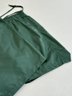 Green Louis Vuitton shorts laid out, with drawstring and elastic waistband.