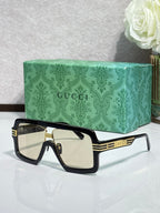Black Gucci glasses with gold trim and light-tinted lenses