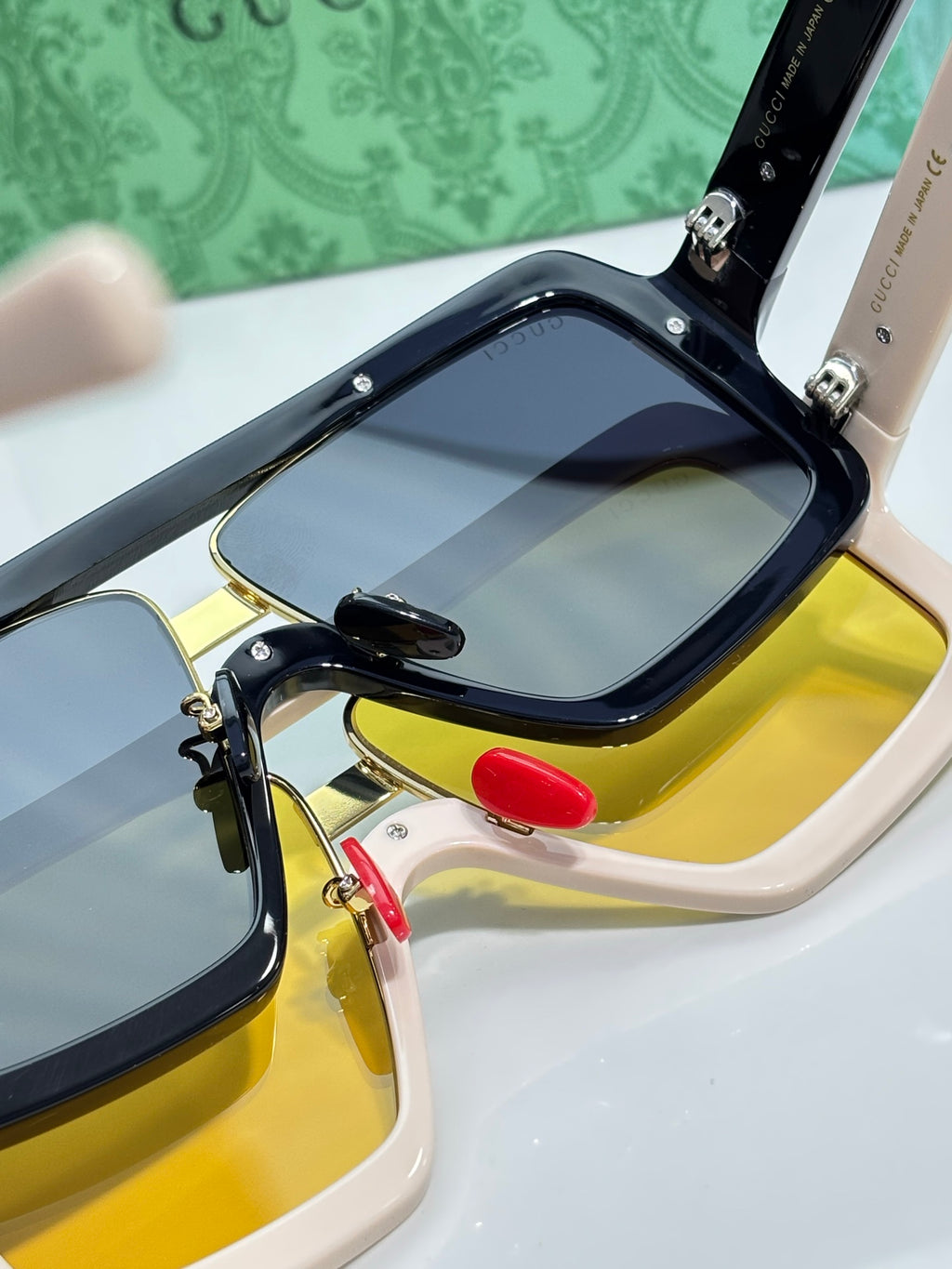 Gucci sunglasses close-up, black frame with gold accents and yellow lenses