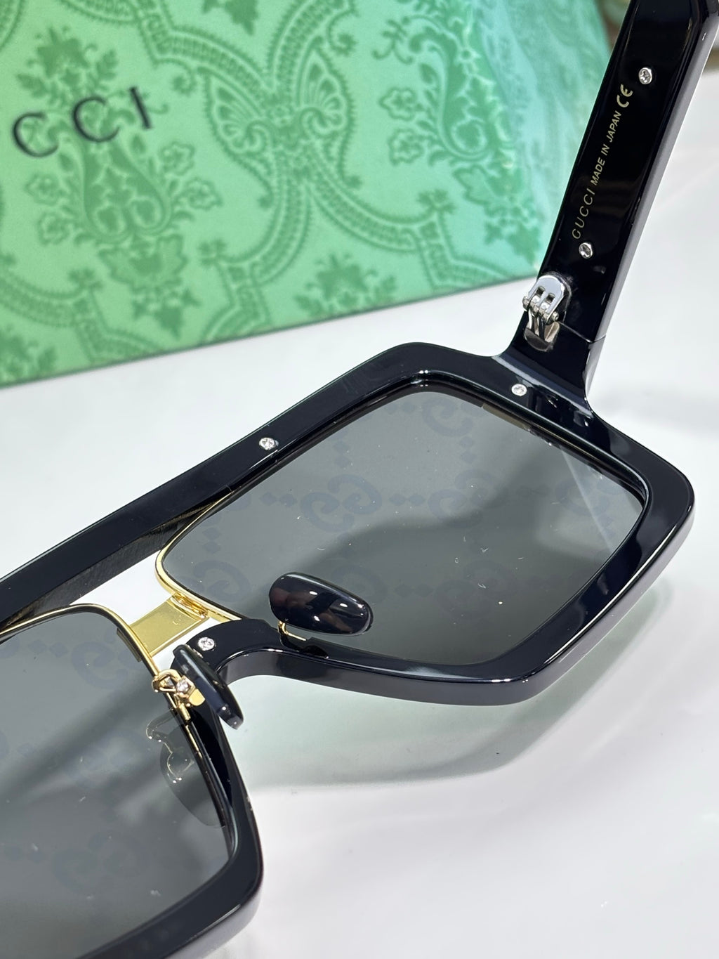 Gucci glasses close-up on temple hinge with dark frame and gold detail