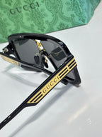 Gucci glasses angled view with dark frames, gold emblem, and GG logo lenses