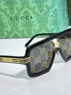 Gucci sunglasses three-quarter view with black frames and gold stripe temple detail