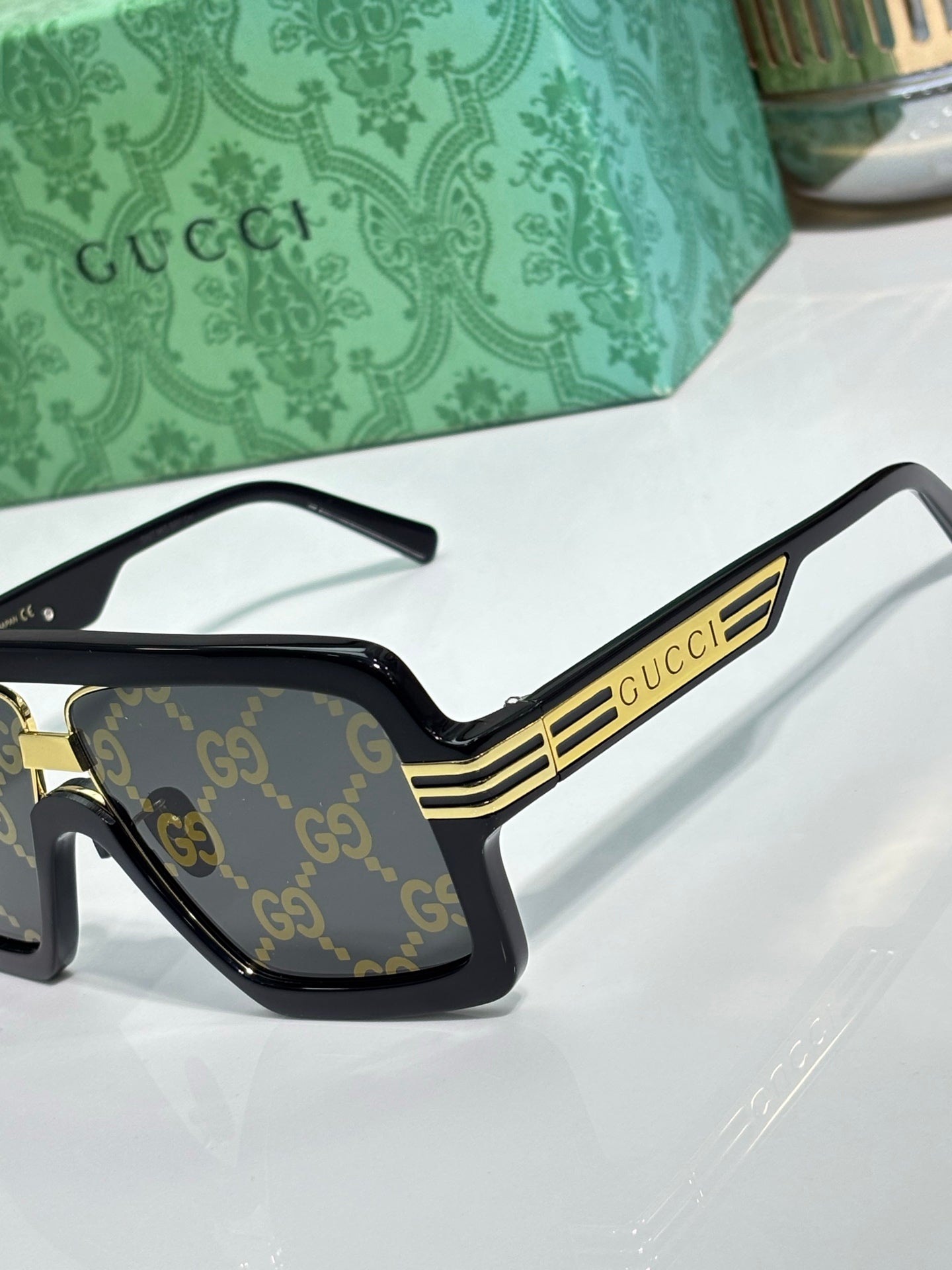 Gucci sunglasses side view with black frames and gold stripe logo detailing