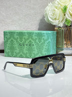 Gucci sunglasses on black frame with gold bar detailing and dark patterned lenses