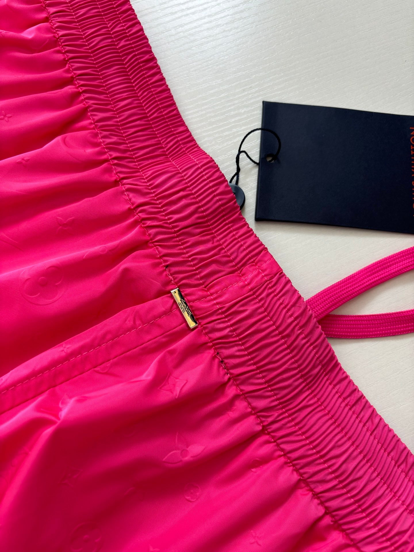 Pink shorts with ruched elastic waistband and small gold zipper detail