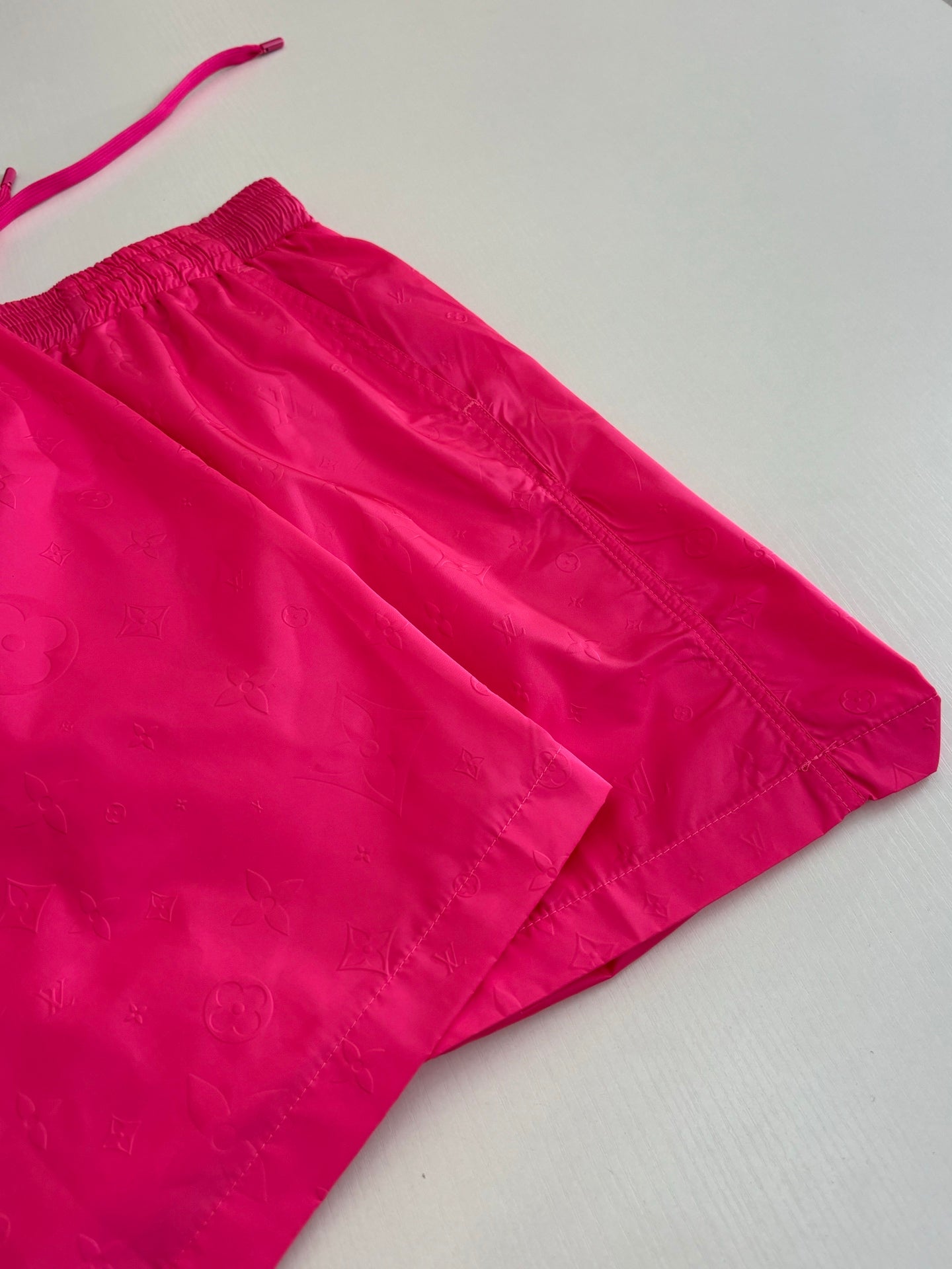 Pink shorts with structured hem and stitched panels at the side