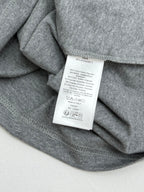 Grey T-shirt fabric with white care tag sewn at inner neck