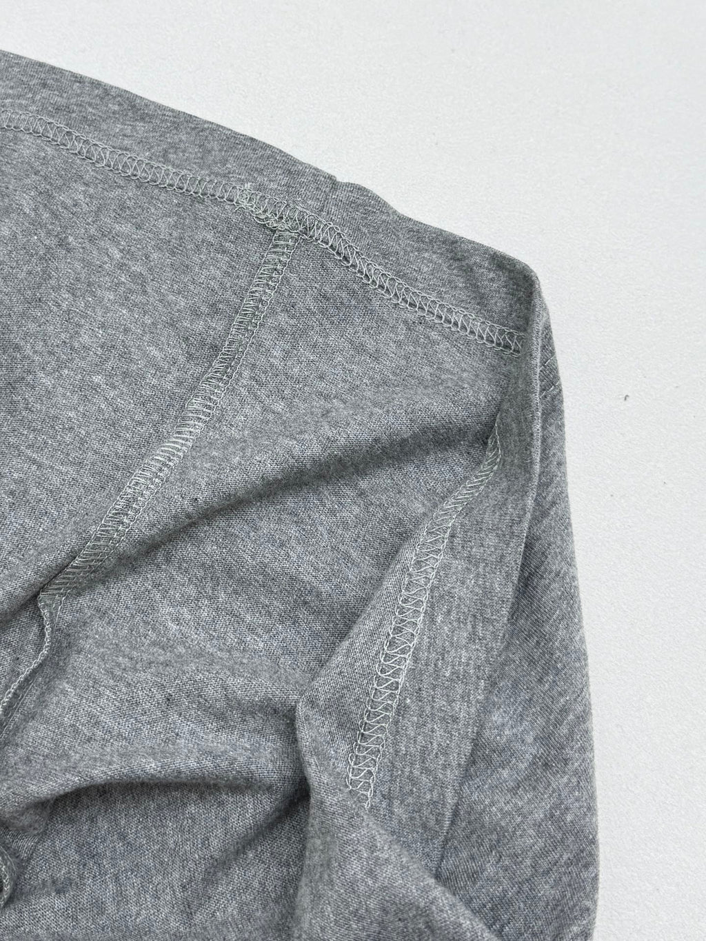 Grey T-shirt side seam with visible stitching detail