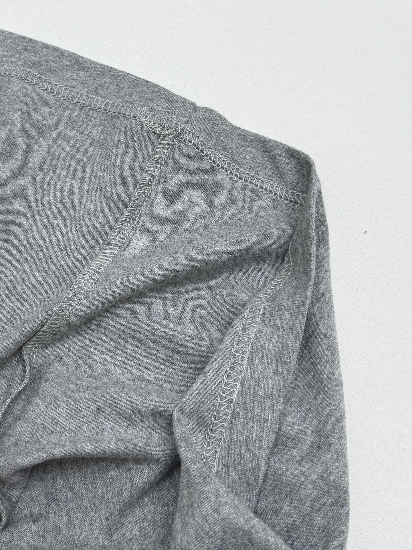 Grey T-shirt side seam with visible stitching detail