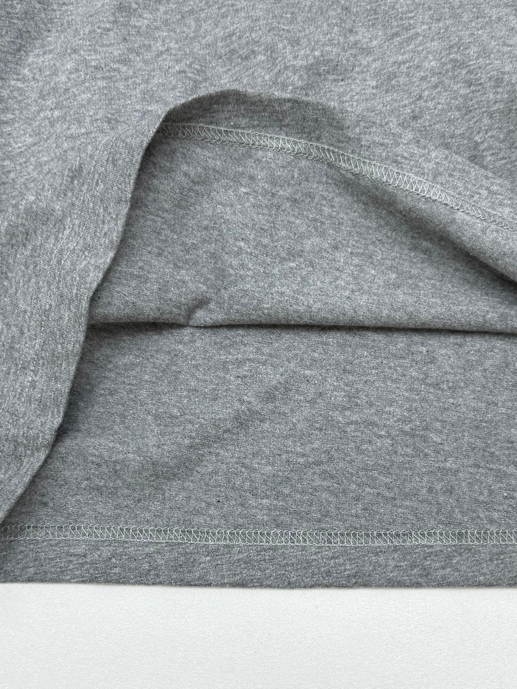 Grey T-shirt shoulder and hem stitching detail