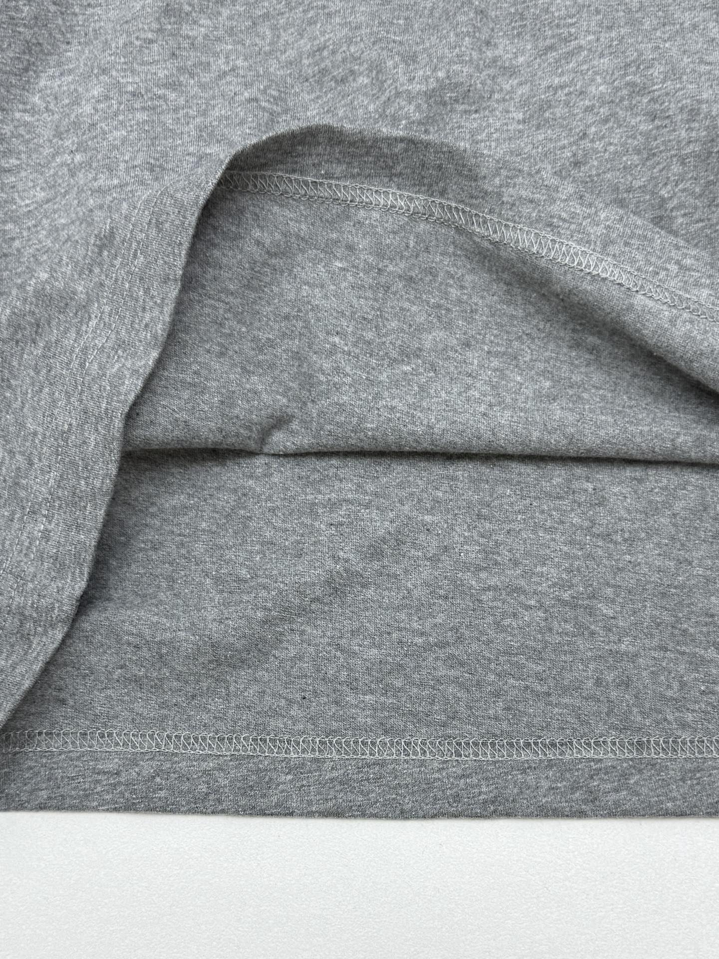Grey T-shirt shoulder and hem stitching detail