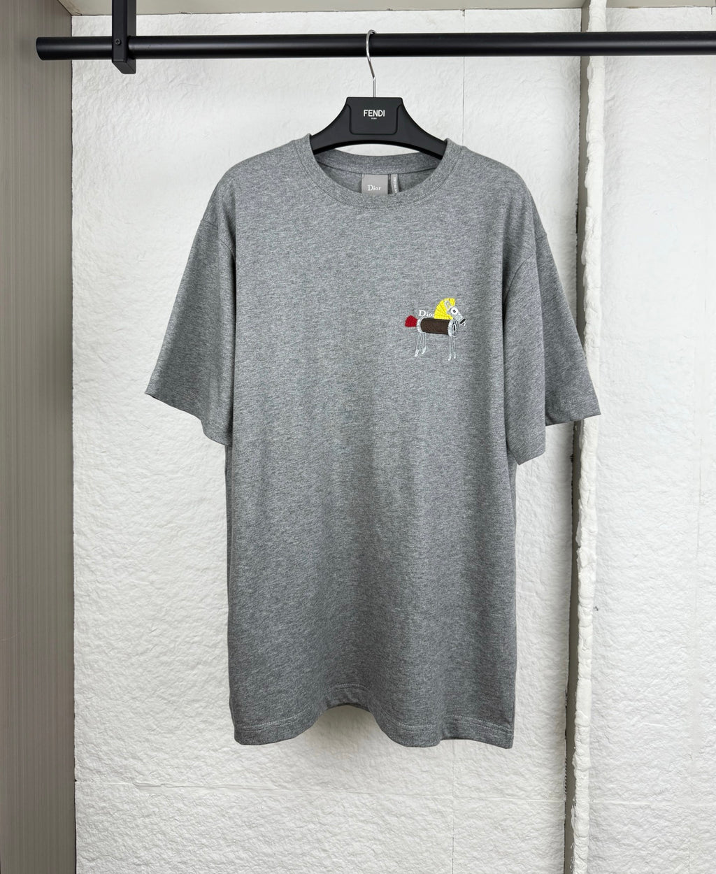 Grey crew-neck T-shirt with short sleeves and small cartoon logo chest print