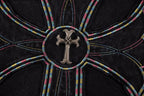 Close-up of circular cross emblem with multicolor stitching on black T-shirt