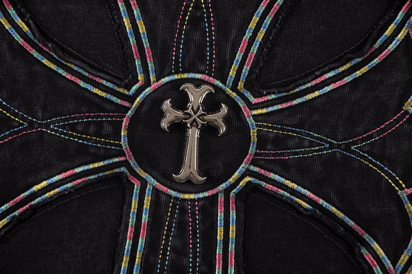 Close-up of circular cross emblem with multicolor stitching on black T-shirt