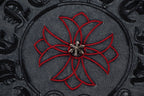 Embroidered circular skull-flower graphic with red petals on dark fabric
