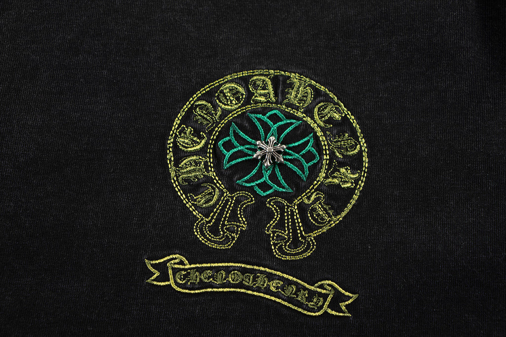 Close-up of teal and gold skull graphic on a dark T-shirt