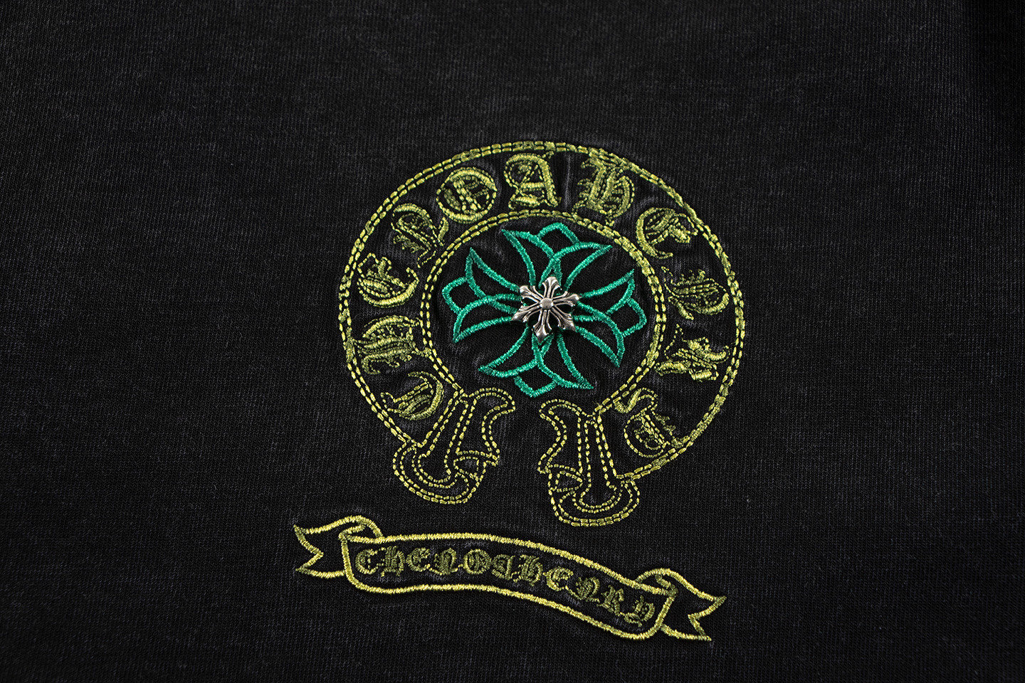 Close-up of teal and gold skull graphic on a dark T-shirt