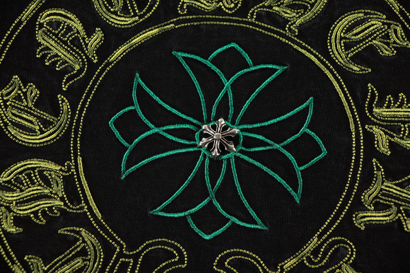Embroidered-style teal flower center with gold ornamental patterns on T-shirt