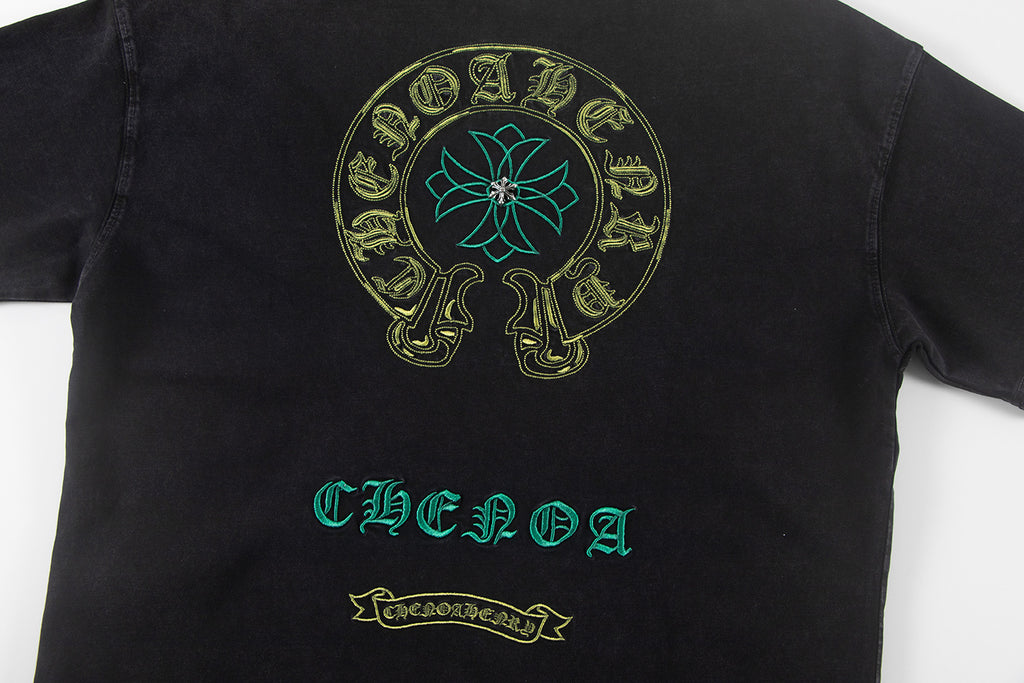 Black graphic T-shirt with round skull emblem and teal-and-gold front text