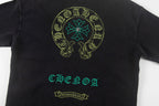 Black graphic T-shirt with round skull emblem and teal-and-gold front text