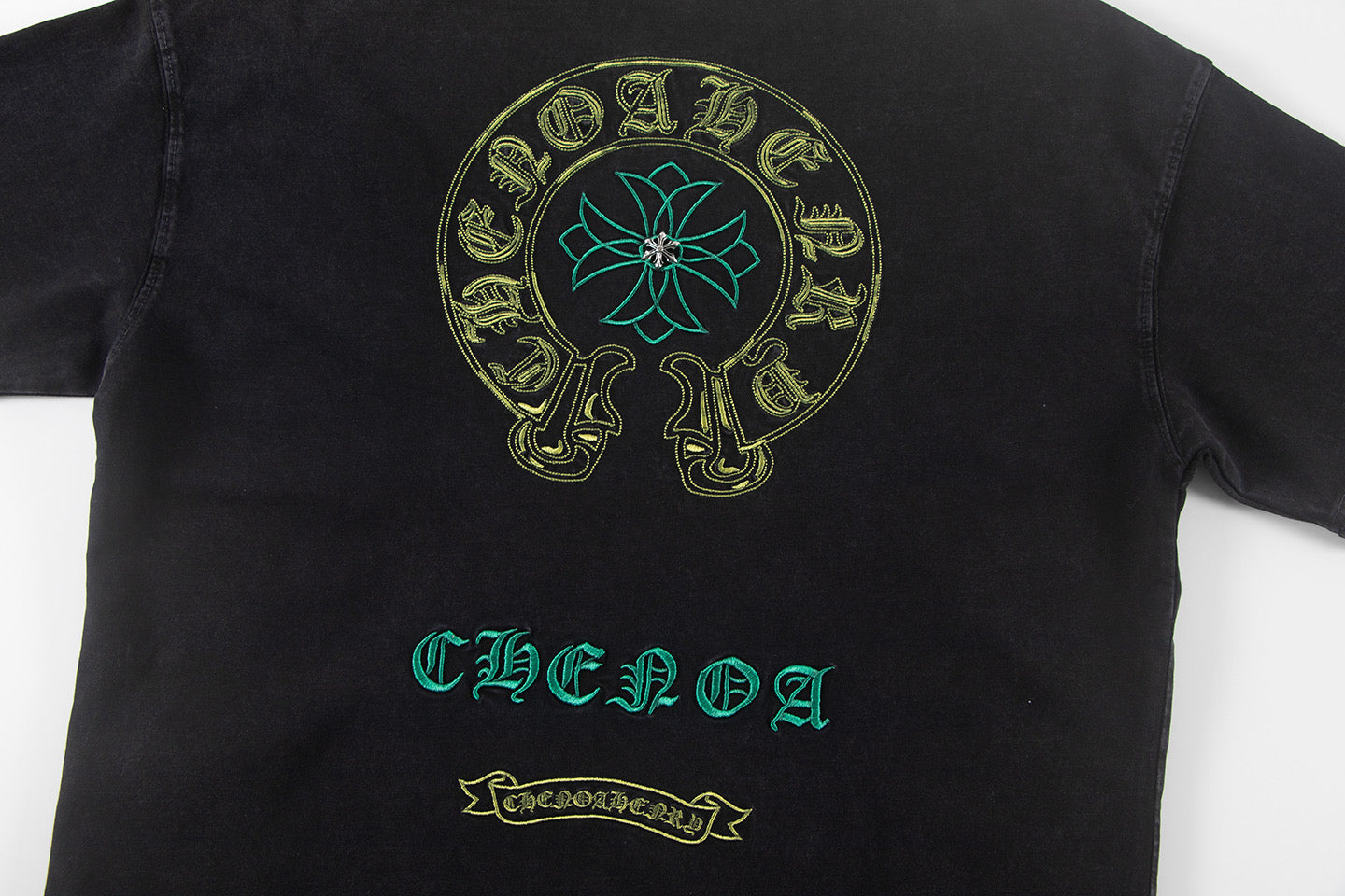 Black graphic T-shirt with round skull emblem and teal-and-gold front text