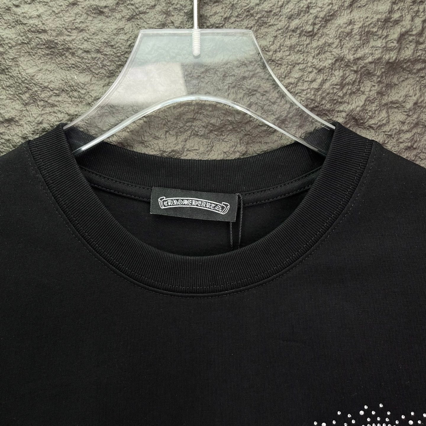 Black crew-neck T-shirt with ribbed collar and small logo label at neckline