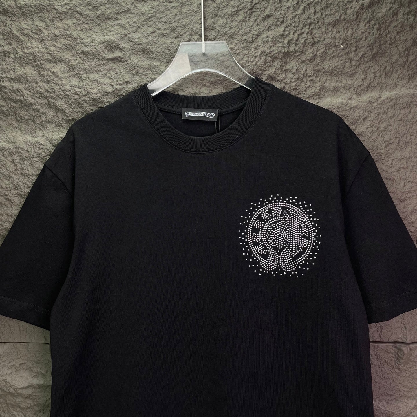 Black short-sleeve T-shirt with small rhinestone circular crest on left chest