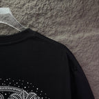 Black T-shirt with rhinestone design near lower back hem area
