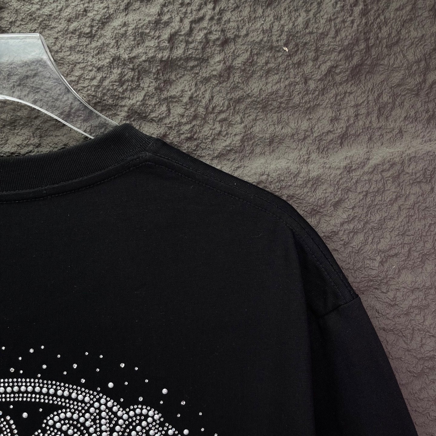 Black T-shirt with rhinestone design near lower back hem area