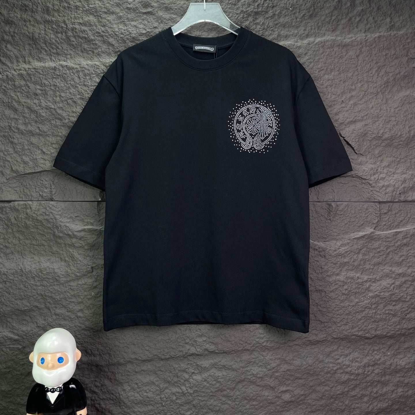 Black short-sleeve T-shirt with small circular rhinestone crest on chest